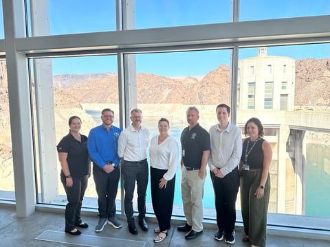 Image (85)Group of 7 people stands in front of window overlooking the Hoover Dam