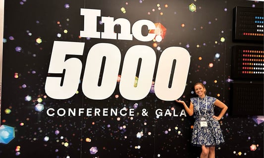 Woman in a dress standing by the Inc. 5000 Conference and Gala sign
