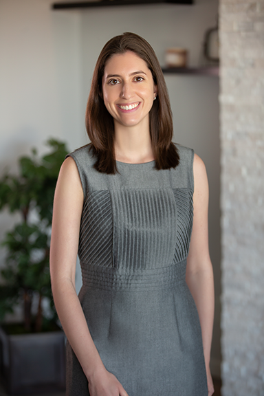 Woman in a grey dress smiling at the camera