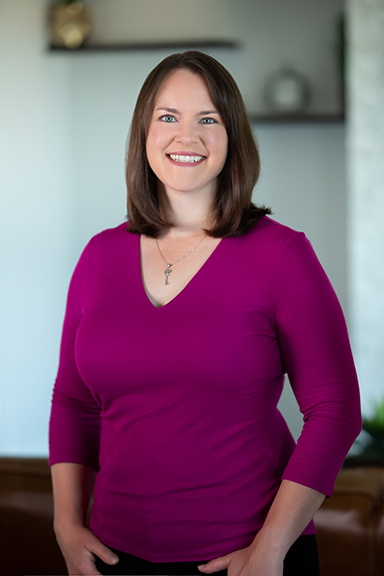 Woman smiling and posing for picture with hands at her sides
